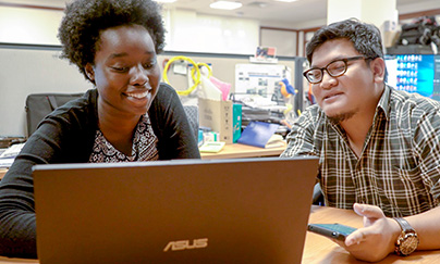 Staff and student discussing over a laptop