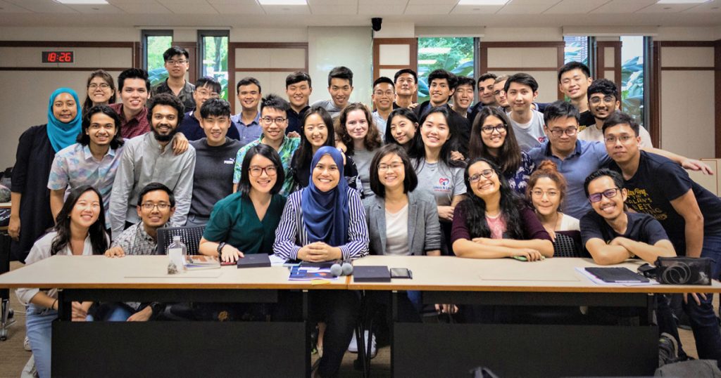 A group picture of 36 people, consisting of Yale-NUS students and CIPE, standing or sitting in four rows in a classroom.