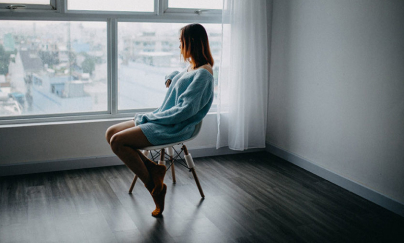 A lady sitting alone in the room.