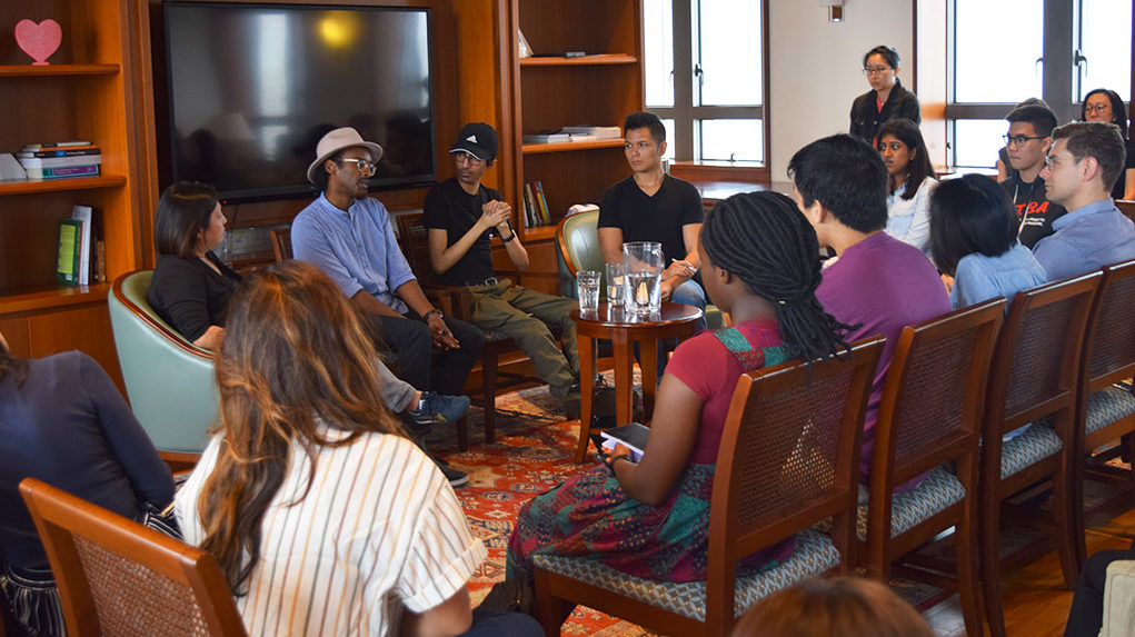 Four people sitting in the front chair, facing the audience sitting on the chairs for an intergroup dialogue at the Saga College Rector’s Commons. 