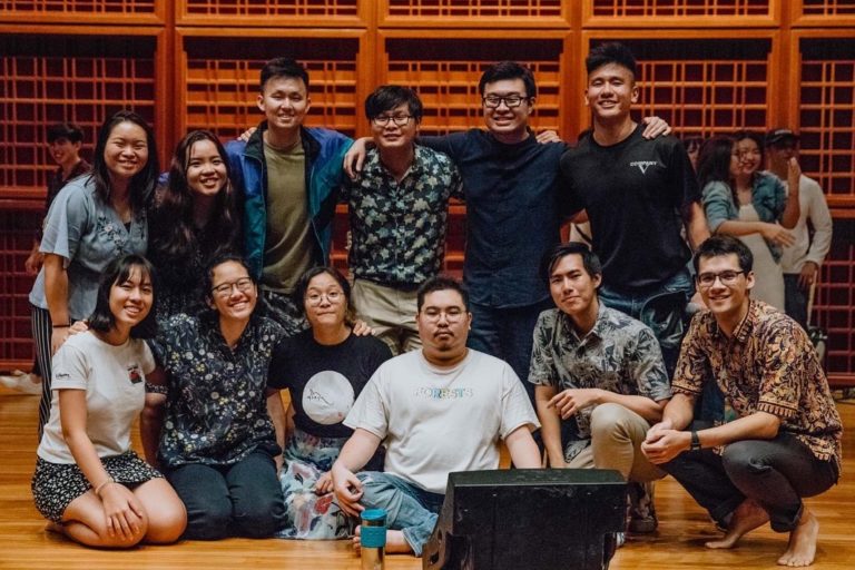 A group of students from the Gospel Choir posing for a picture on stage at the Yale-NUS Performance Hall.
