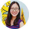 A headshot of smiling Grace Kwak who has long brown hair past her shoulders, wearing glasses and blue-red stripes sleeveless shirt with grey and yellow art in the background.