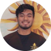 A headshot of smiling Grady Ng who has short black hair, wearing black t-shirt with sun wallpaper in the background.